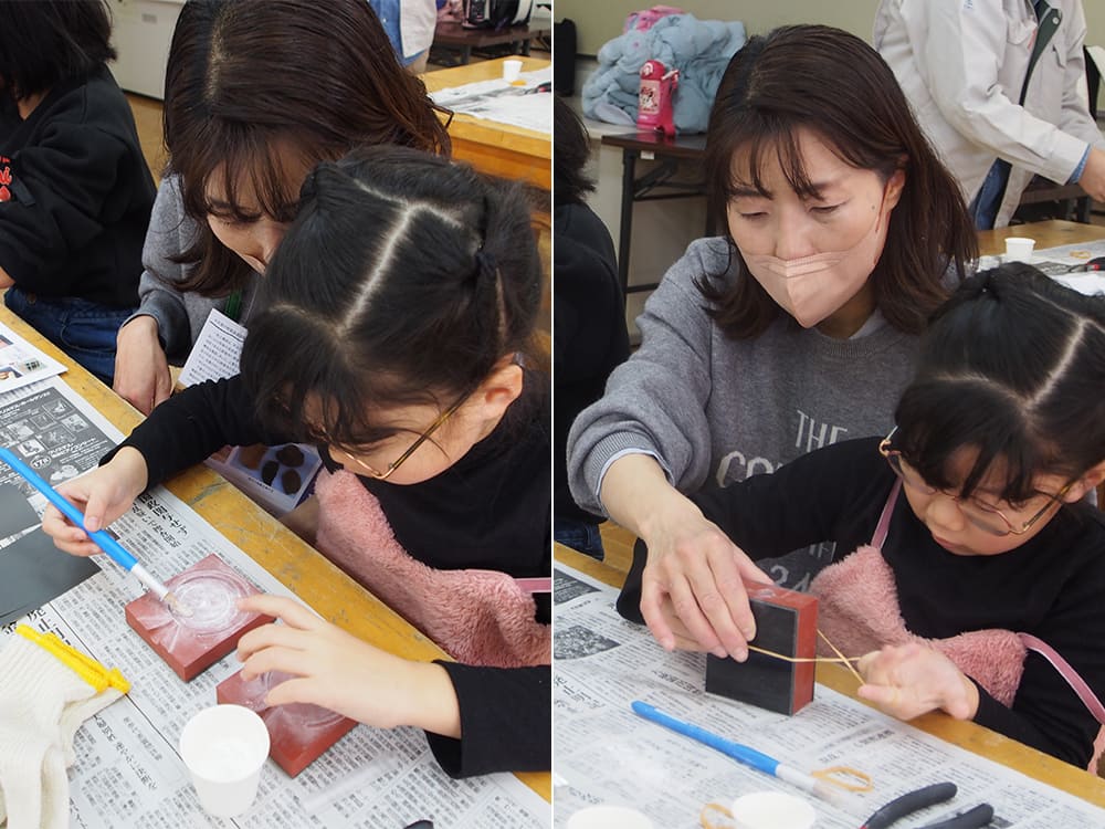 銅鏡製作体験中の親子