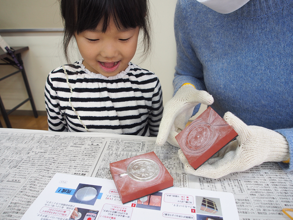 銅鏡製作体験中の親子2