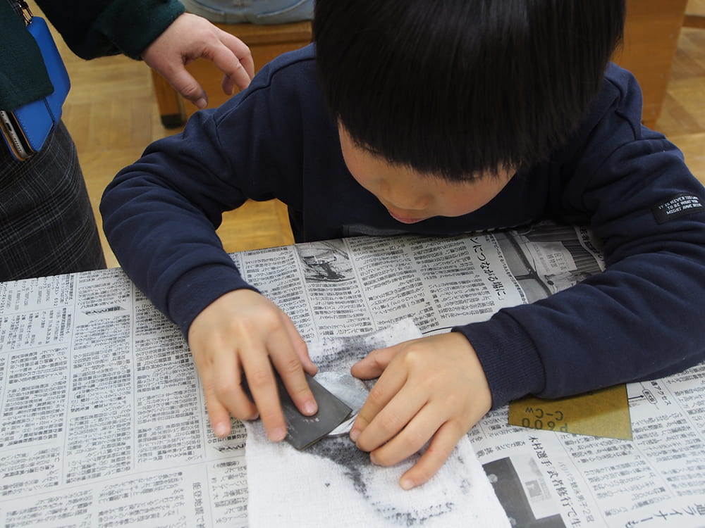 銅鏡製作体験中の男の子