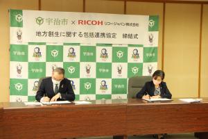 包括連携協定締結式での署名の様子